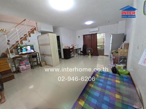 Spacious living room with a staircase and TV