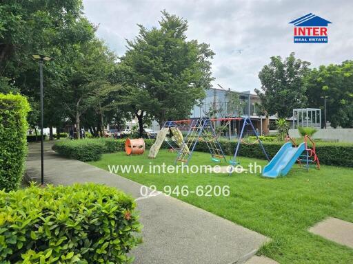 Community playground area with swings, slides, and greenery