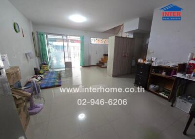 Living room with tiled floor, a fan, a wardrobe, a rug, and a staircase to the upper level