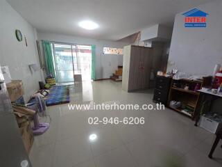 Living room with tiled floor, a fan, a wardrobe, a rug, and a staircase to the upper level