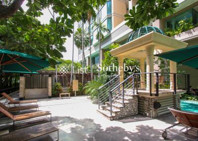 Outdoor lounge area with poolside and greenery