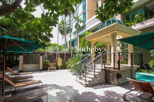 Outdoor lounge area with poolside and greenery