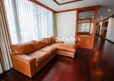 Spacious living room with large windows and leather sofa