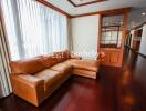 Spacious living room with large windows and leather sofa