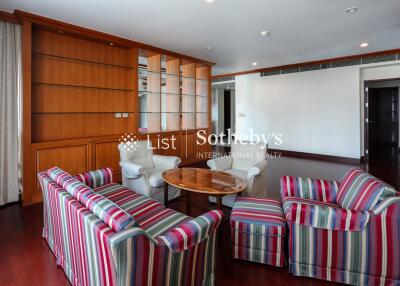 Living room with striped chairs and wooden built-in shelves