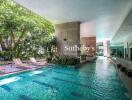 Indoor swimming pool with lounging chairs and greenery