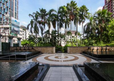 Outdoor area with fountains and palm trees in a luxury urban development