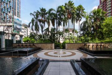 Outdoor area with fountains and palm trees in a luxury urban development