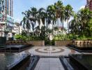 Outdoor area with fountains and palm trees in a luxury urban development