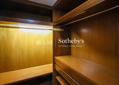 Spacious wooden walk-in closet with ample lighting