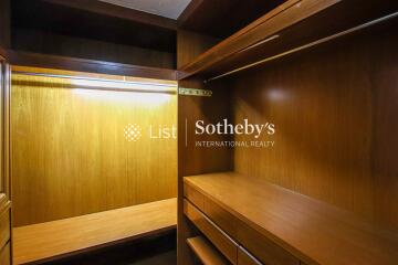 Spacious wooden walk-in closet with ample lighting