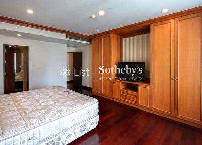 Spacious bedroom with wooden built-in wardrobe and television stand