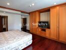 Spacious bedroom with wooden built-in wardrobe and television stand