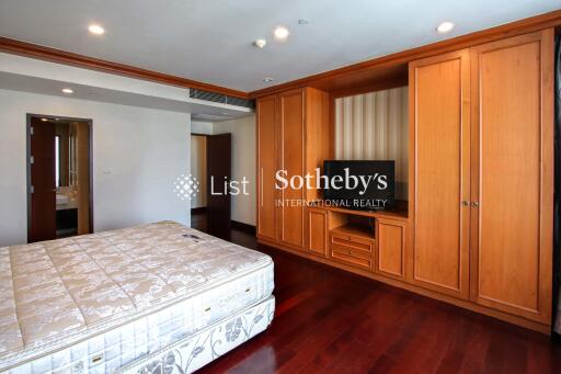 Spacious bedroom with wooden built-in wardrobe and television stand