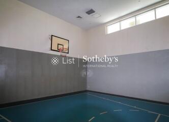 Indoor basketball court with hoop and natural light