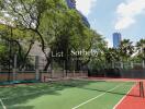 Outdoor tennis court with trees and high rise buildings