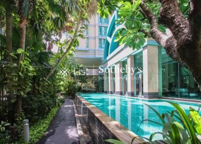 Outdoor swimming pool surrounded by lush greenery