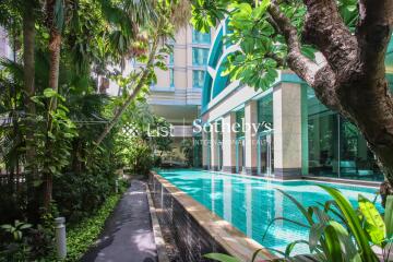 Outdoor swimming pool surrounded by lush greenery