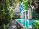 Outdoor swimming pool surrounded by lush greenery