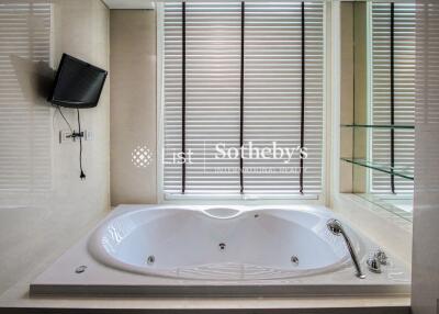 Modern bathroom with a large bathtub and wall-mounted TV