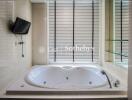 Modern bathroom with a large bathtub and wall-mounted TV