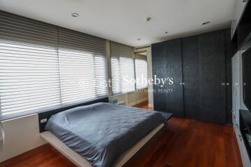 Modern bedroom with large windows and wooden flooring