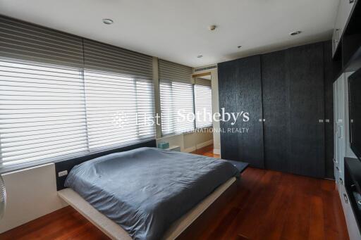 Modern bedroom with large windows and wooden flooring