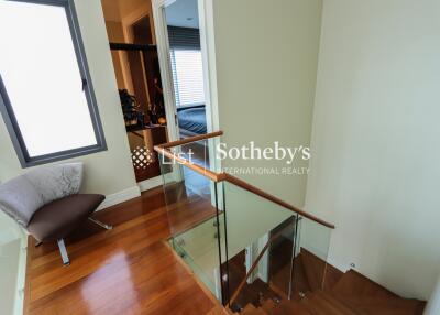 Staircase landing with glass railing and window