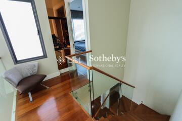 Staircase landing with glass railing and window