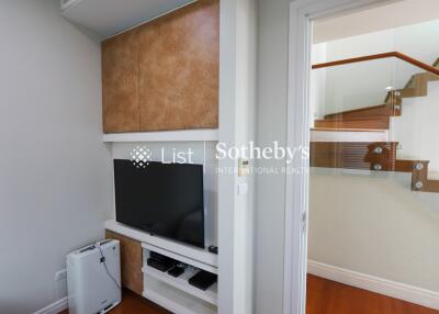 Living room corner with TV and staircase