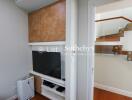 Living room corner with TV and staircase