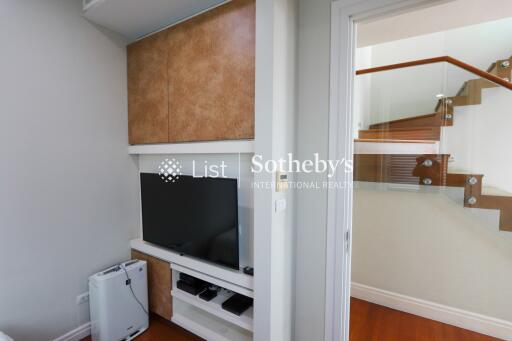 Living room corner with TV and staircase