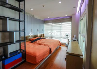 Cozy bedroom with orange bed covers and natural light