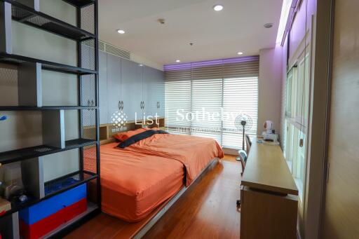 Cozy bedroom with orange bed covers and natural light