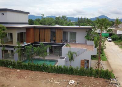 Exterior view of a modern two-story house with a pool