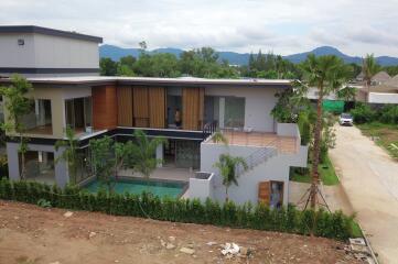 Exterior view of a modern two-story house with a pool