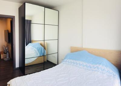 Bedroom interior with a bed, mirrored wardrobe, and window