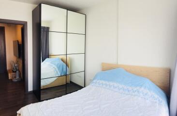 Bedroom interior with a bed, mirrored wardrobe, and window