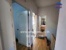 Hallway with doors leading to different rooms, featuring wooden flooring.