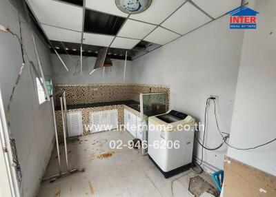 A kitchen in need of renovation with tiled backsplash and countertop space.