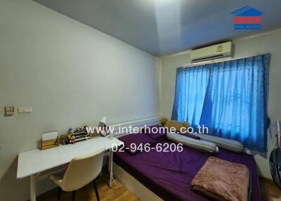 Bedroom with bed, desk, and window with blue curtains