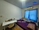 Bedroom with bed, desk, and window with blue curtains