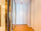 Modern hallway with mirrored closet doors and wood flooring