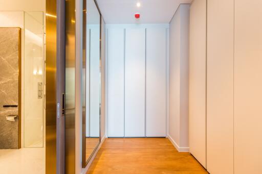 Modern hallway with mirrored closet doors and wood flooring