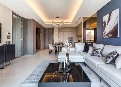 Modern living room with sofas, dining area, and kitchen