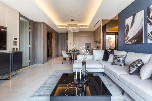 Modern living room with sofas, dining area, and kitchen