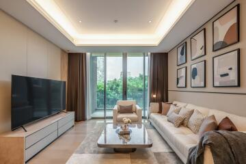 Modern living room with a large TV, sofa, coffee table, and artwork on the wall