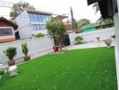 Backyard with artificial grass and plants