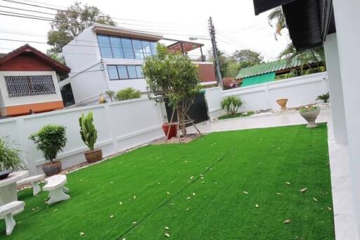 Backyard with artificial grass and plants