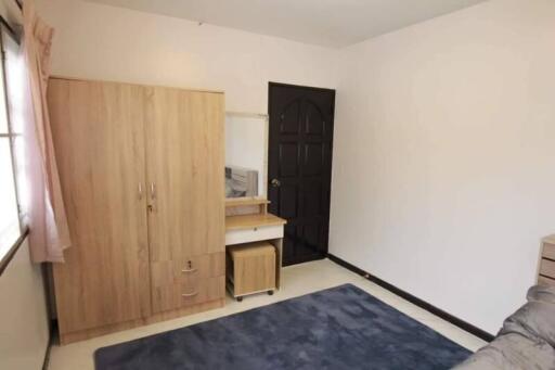 Bedroom with wardrobe, desk with chair, and dark door